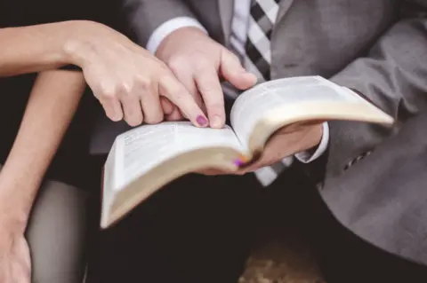 view-couple-reading-book-together-while-pointing-out-part-page-1-2