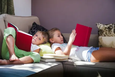 siblings-with-books-sofa