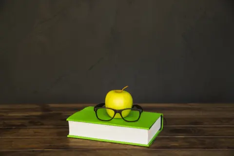 colorful-book-with-glasses-apple-desk