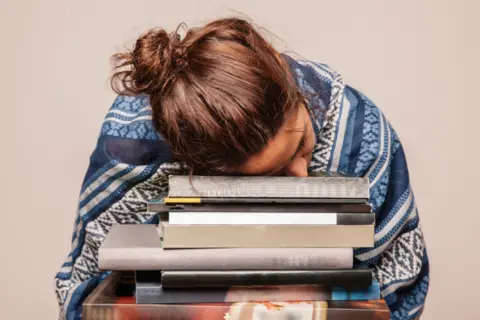 girl-sleeping-pile-books