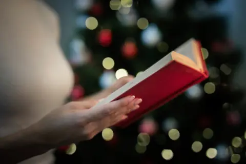 close-up-woman-holding-book-with-stories-christmas