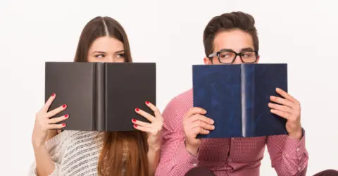 man-woman-hiding-books-smiling-people-preparing-their-exams-white