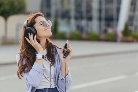 young-pretty-student-girl-waiting-taxi-car-listening-music-1