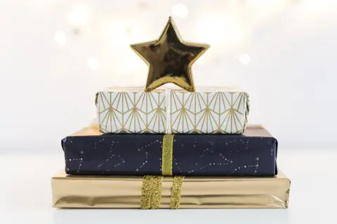 6-gift-boxes-sweetie-papers-with-ornament-star-near-fairy-lights